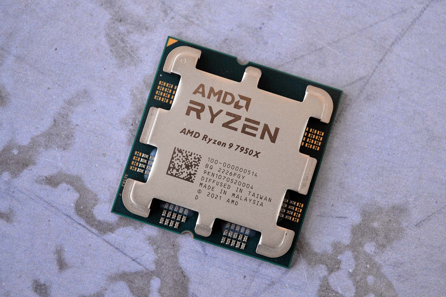 The AMD Ryzen 9 7950X lying on a marble table.