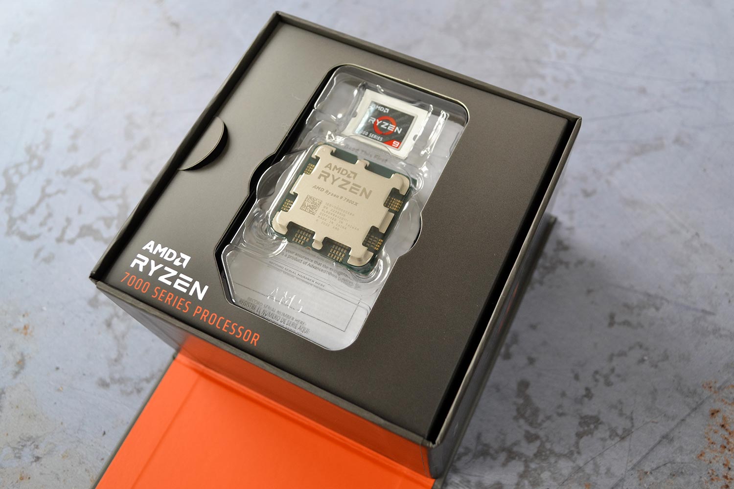 The AMD Ryzen 9 7900X CPU sitting in the retail box.