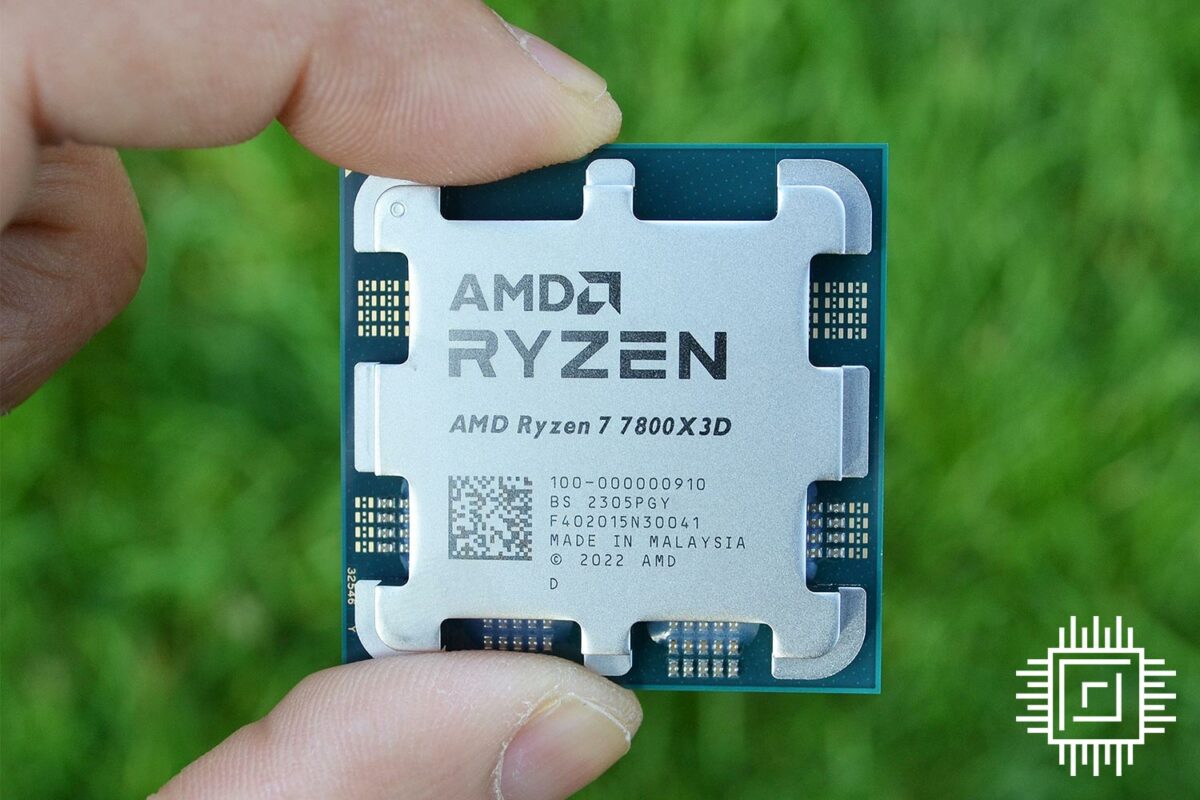 The AMD Ryzen 7 7800X3D held above green grass.