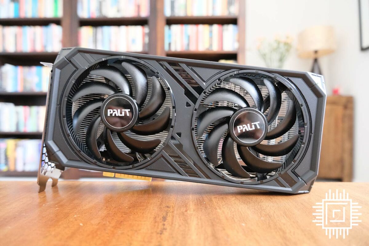 A dual-fan Palit Nvidia GeForce RTX 4060 balancing in front of a bookcase.