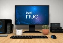 Intel Nuc mini-PCs sitting on a table next to a monitor and some peripherals