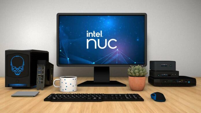 Intel Nuc mini-PCs sitting on a table next to a monitor and some peripherals