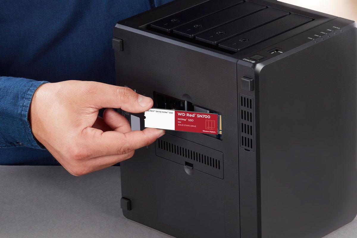A WD Red drive in front of a NAS.