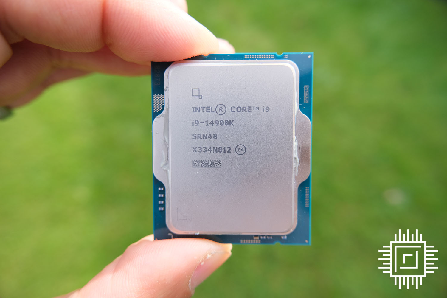 The Intel Core i9-14900K held in fingers.