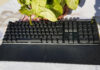 Corsair K70 Core RGB mechanical keyboard near a green plant.