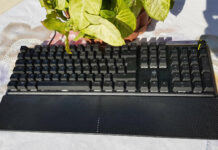 Corsair K70 Core RGB mechanical keyboard near a green plant.