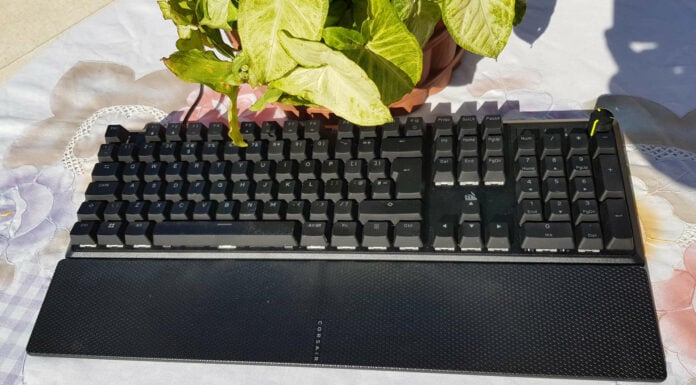 Corsair K70 Core RGB mechanical keyboard near a green plant.