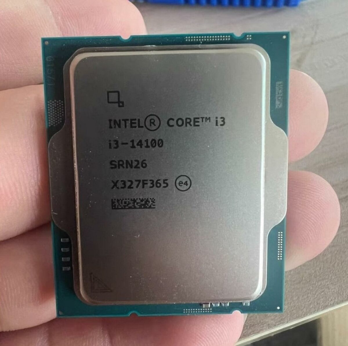 The Intel Core i3-14100 desktop processor in someone's fingertips.