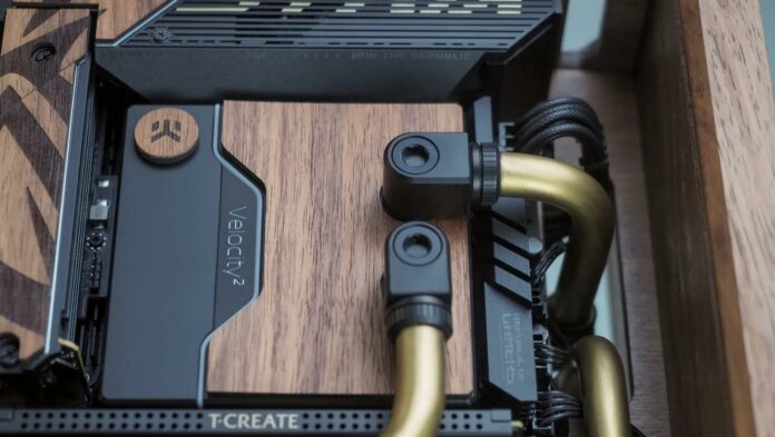 The CPU water block on a small form factor computer chassis made from wood.