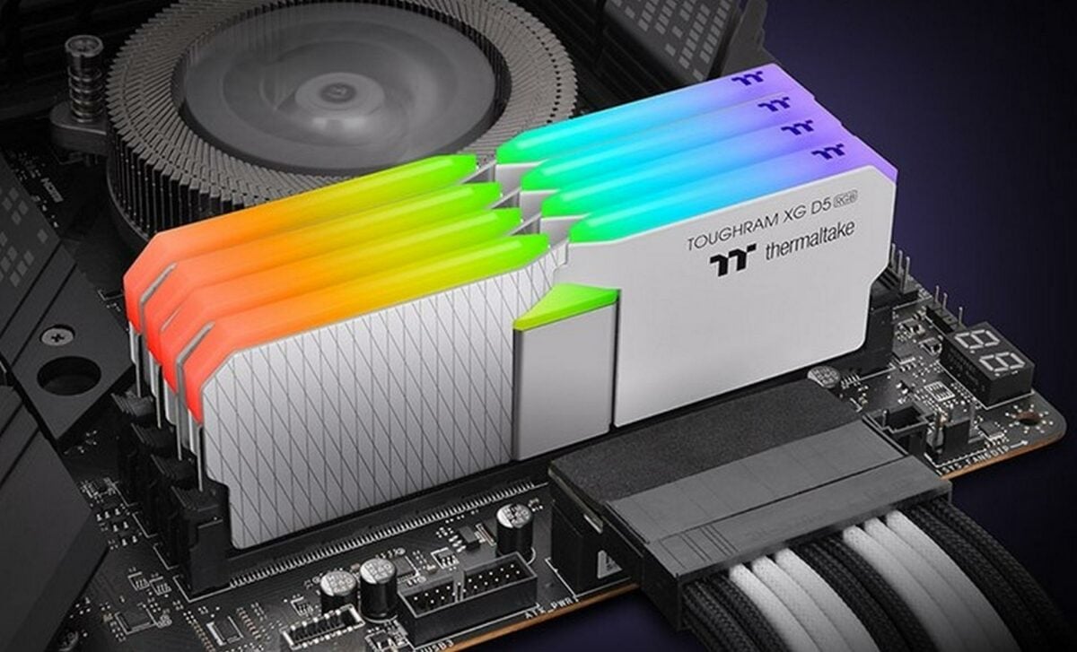 Four Thermaltake ToughRAM XG RGB D5 white DDR5 memory modules sitting in a motherboard.