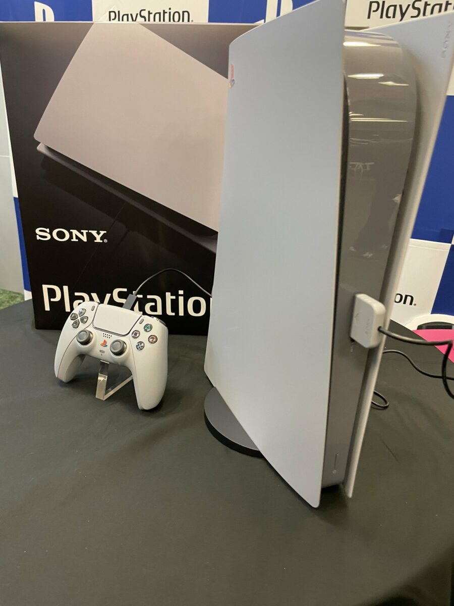 The one-of-a-kind PS5 with its controller, both decked out in PS1 Classic grey with a multicoloured logo.