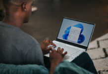 Person working on Windows 11 Laptop on the couch.