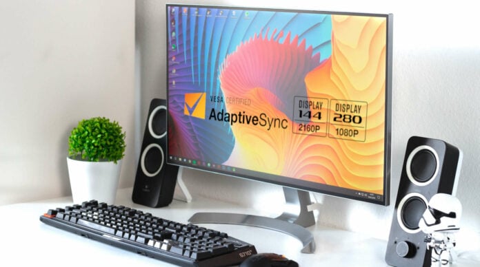 A computer monitor and peripherals on a white desk.