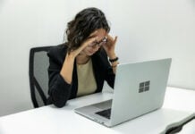 Windows 11 is broken - Tired Young Female Employee Feeling Stressed, Headache, and Burnout from Computer Work.