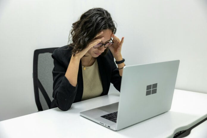 Windows 11 is broken - Tired Young Female Employee Feeling Stressed, Headache, and Burnout from Computer Work.