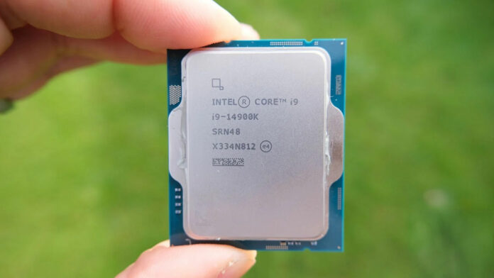 Intel Core i9 14900K processor, held between two fingers, against a blurred green background