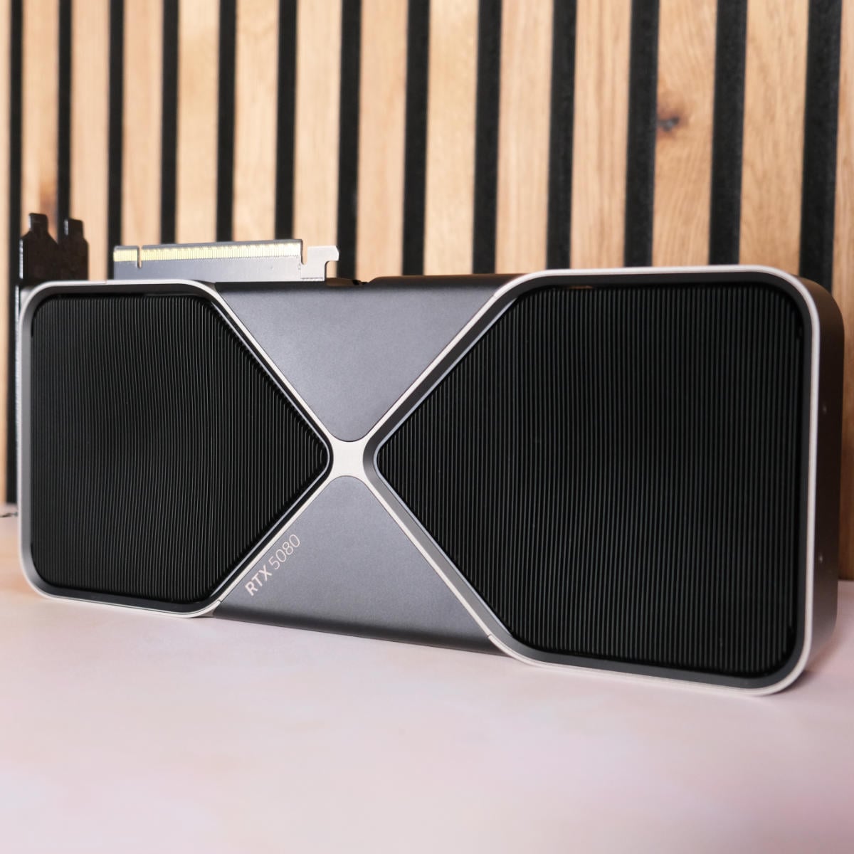 Nvidia GeForce RTX 5080 Founders Edition posing against wood panelling with a right angle.