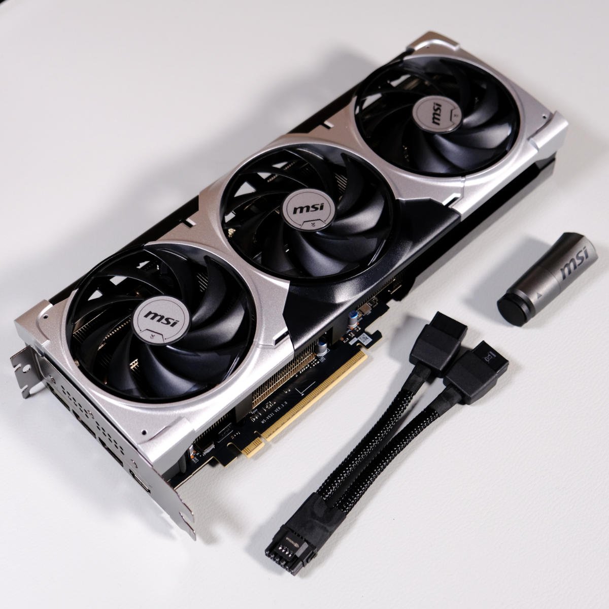 MSI GeForce RTX 5070 Ti Ventus 3X graphics card with its accessories, including the dual eight-pin adapter and an extendable support bracket.