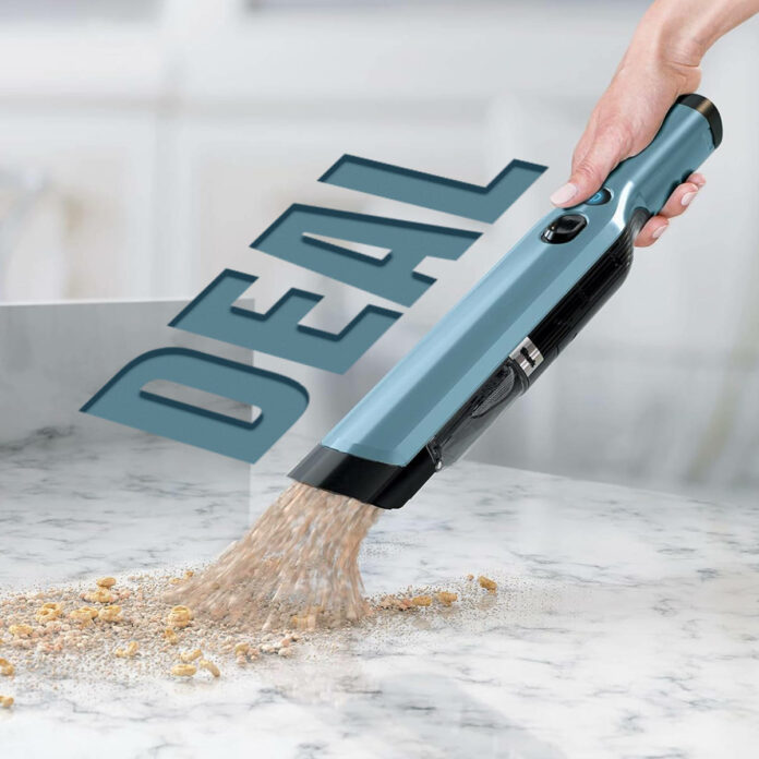 Shark WandVac in hand cleaning up a mess with the word 