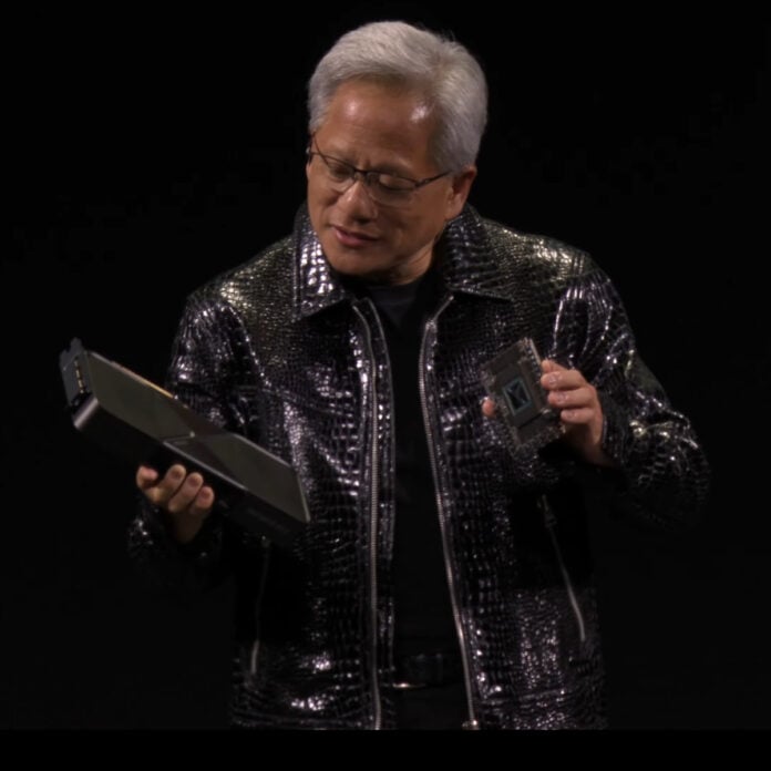Nvidia CEO Jensen Huang looks down at a GeForce RTX 5090 Founders Edition in his hand, while holding a Blackwell GPU in his other hand.