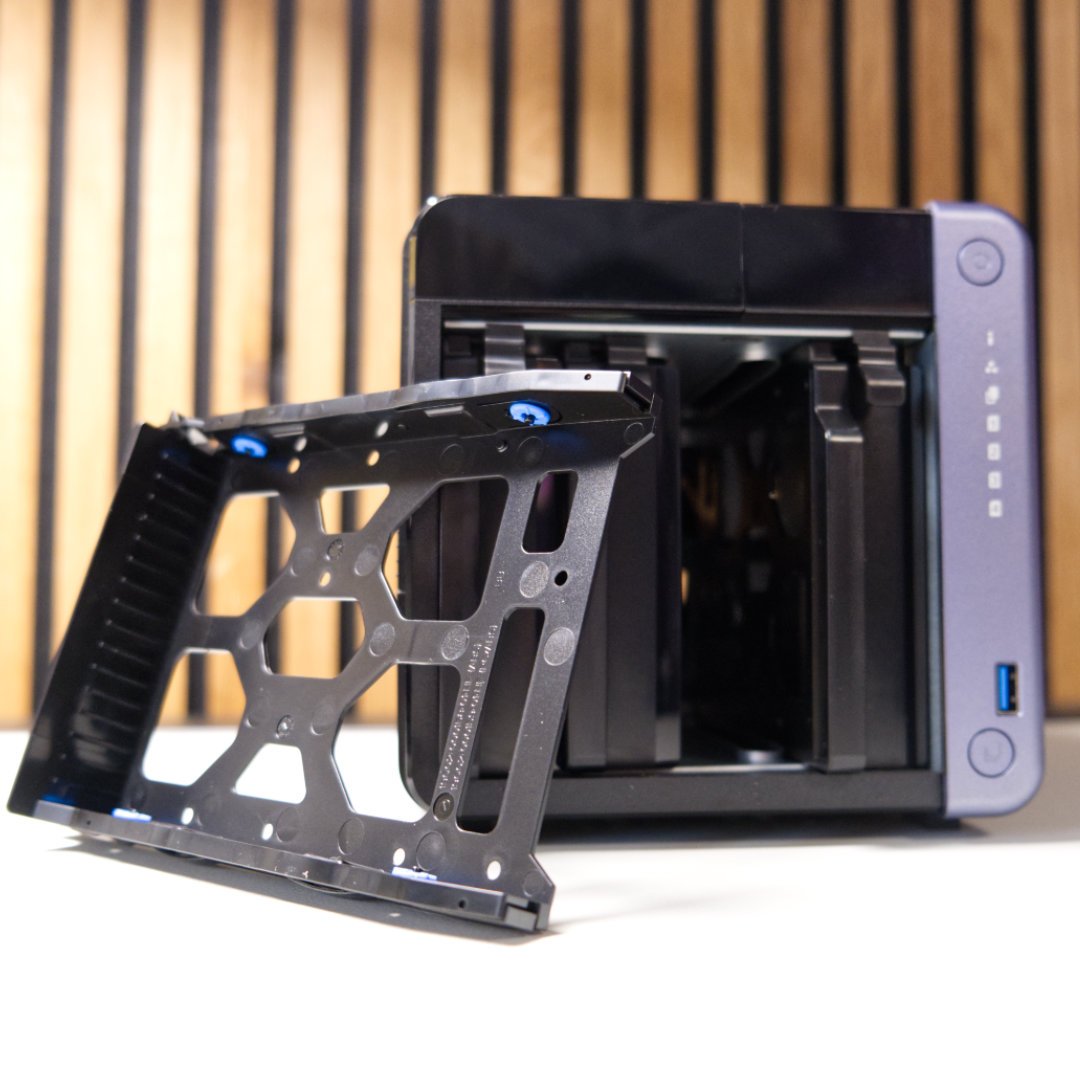 QNAP TS-432X empty HDD tray sliding out of enclosure.