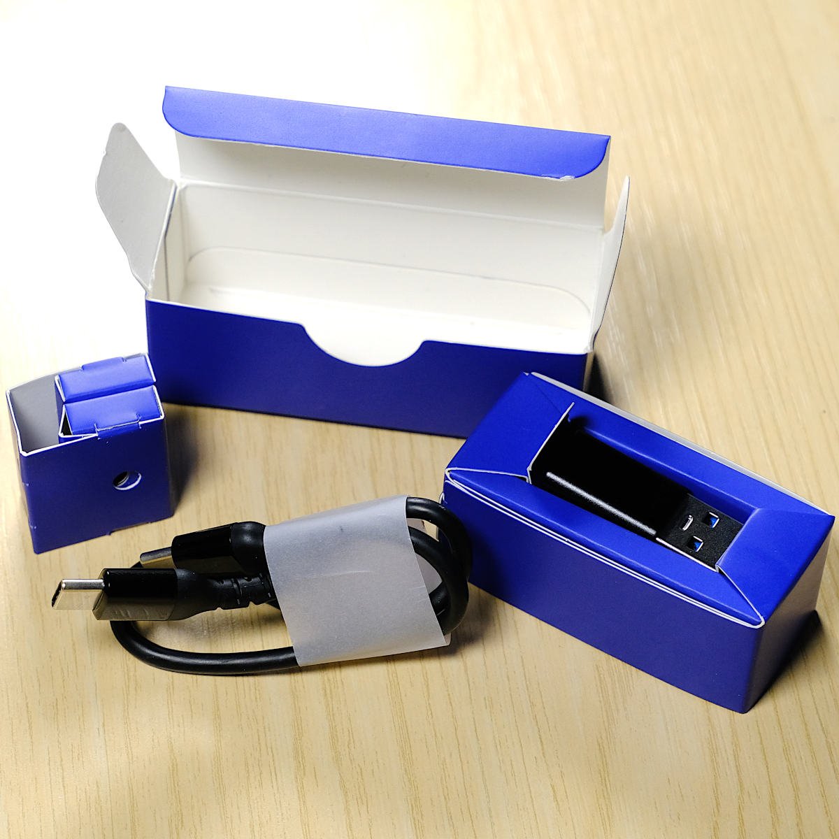 Accessories box for SteelSeries Arctis GameBuds open, showcasing spared eartips (left), charging cable (centre) and Type-A convertor (right).