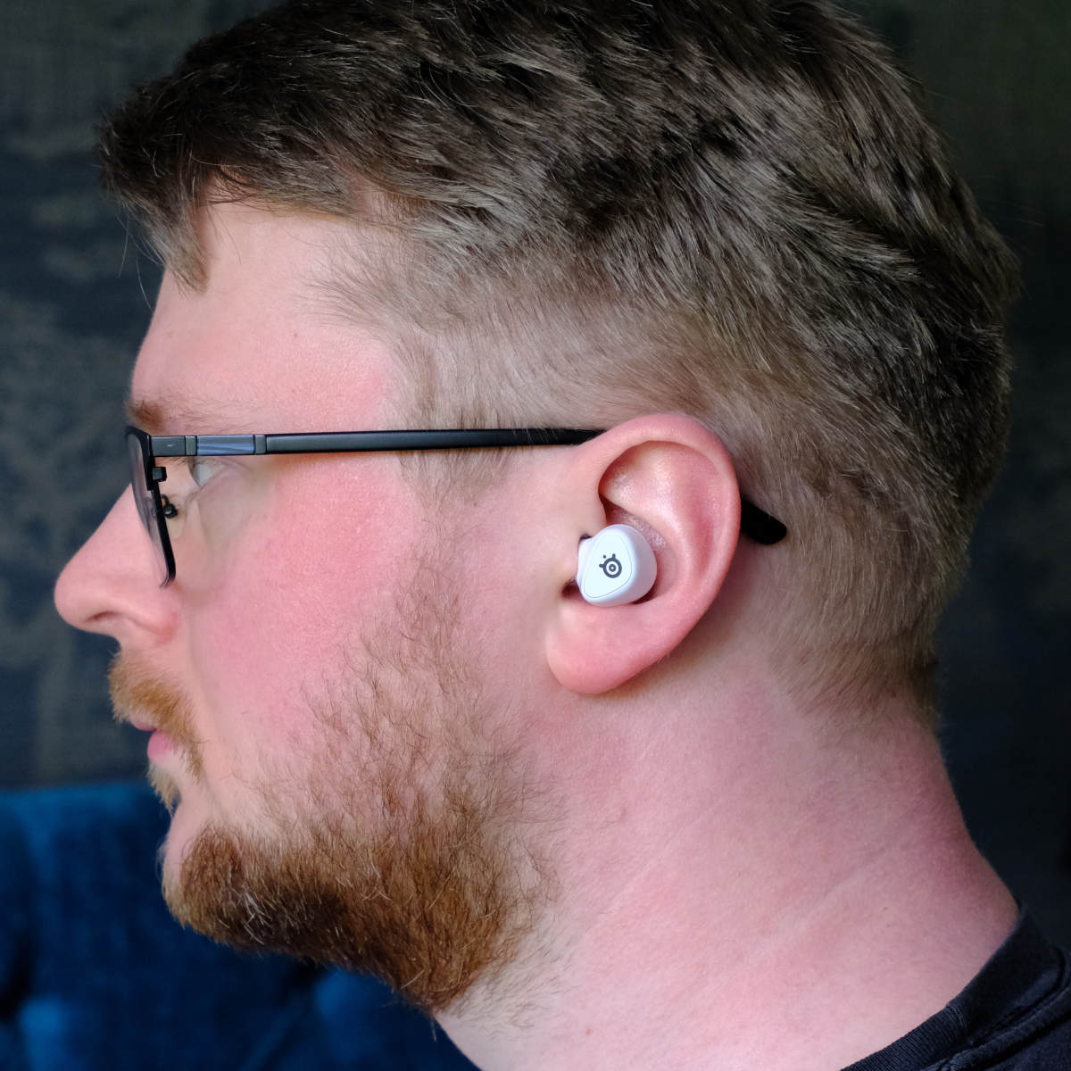 SteelSeries Arctis GameBuds in a person's ear.