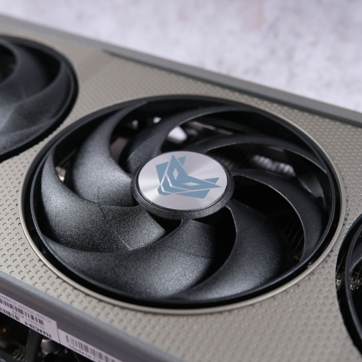 Close up of Sapphire Nitro+ Radeon RX 9060 XT 16GB fan, featuring an etched logo in its centre.