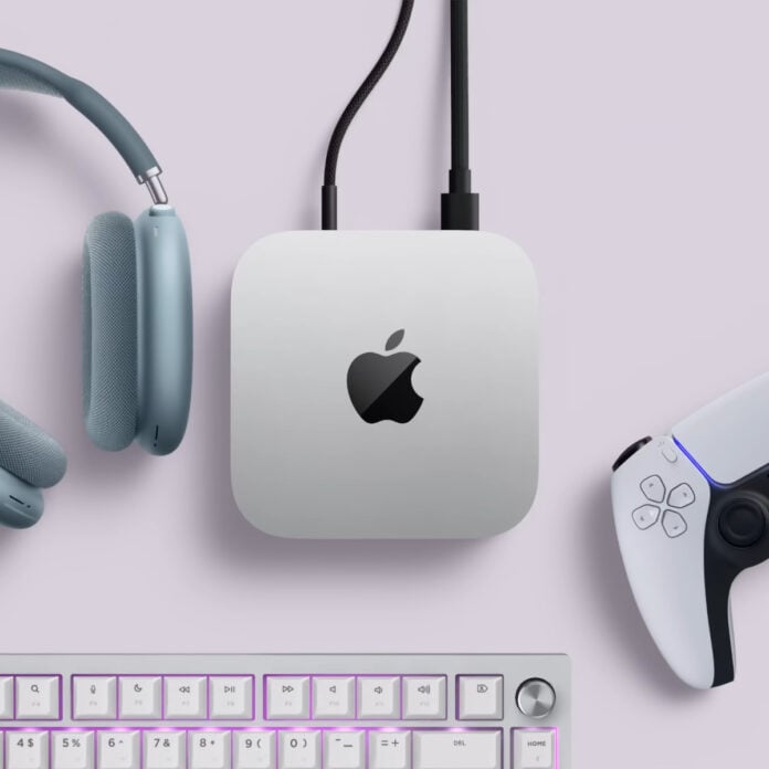 Apple Mac Mini surrounded by headphones (left), a gamepad (right), and keyboard (bottom).