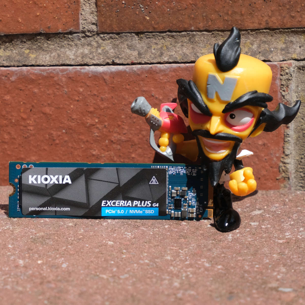 Kioxia Exceria Plus G4 2TB SSD stands upright next to a figurine of Dr. Neo Cortex.