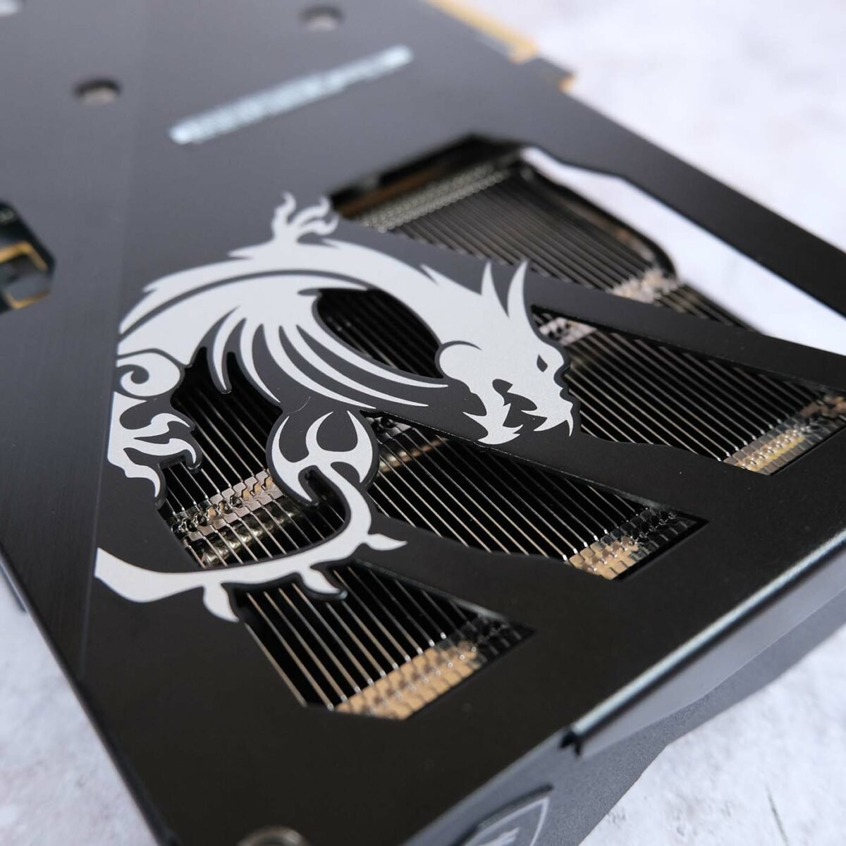Close up of MSI dragon logo on the backplate of GeForce RTX 5060 Gaming OC, showcasing the heatsink underneath it.