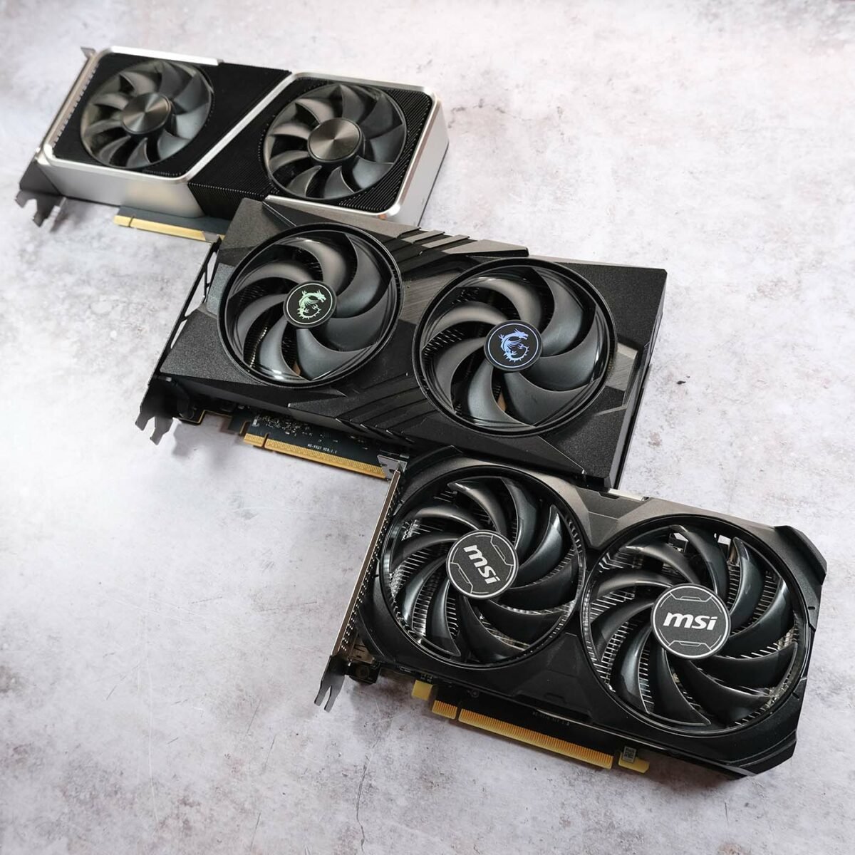 MSI GeForce RTX 5060 Gaming OC sits in the middle, surrounded by an Nvidia GeForce RTX 3060 Ti Founders Edition (top left) and MSI GeForce RTX 4060 Ventus 2X (bottom right).