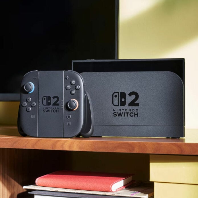 Switch 2 console in its dock, with a controller standing upright next to it (left).