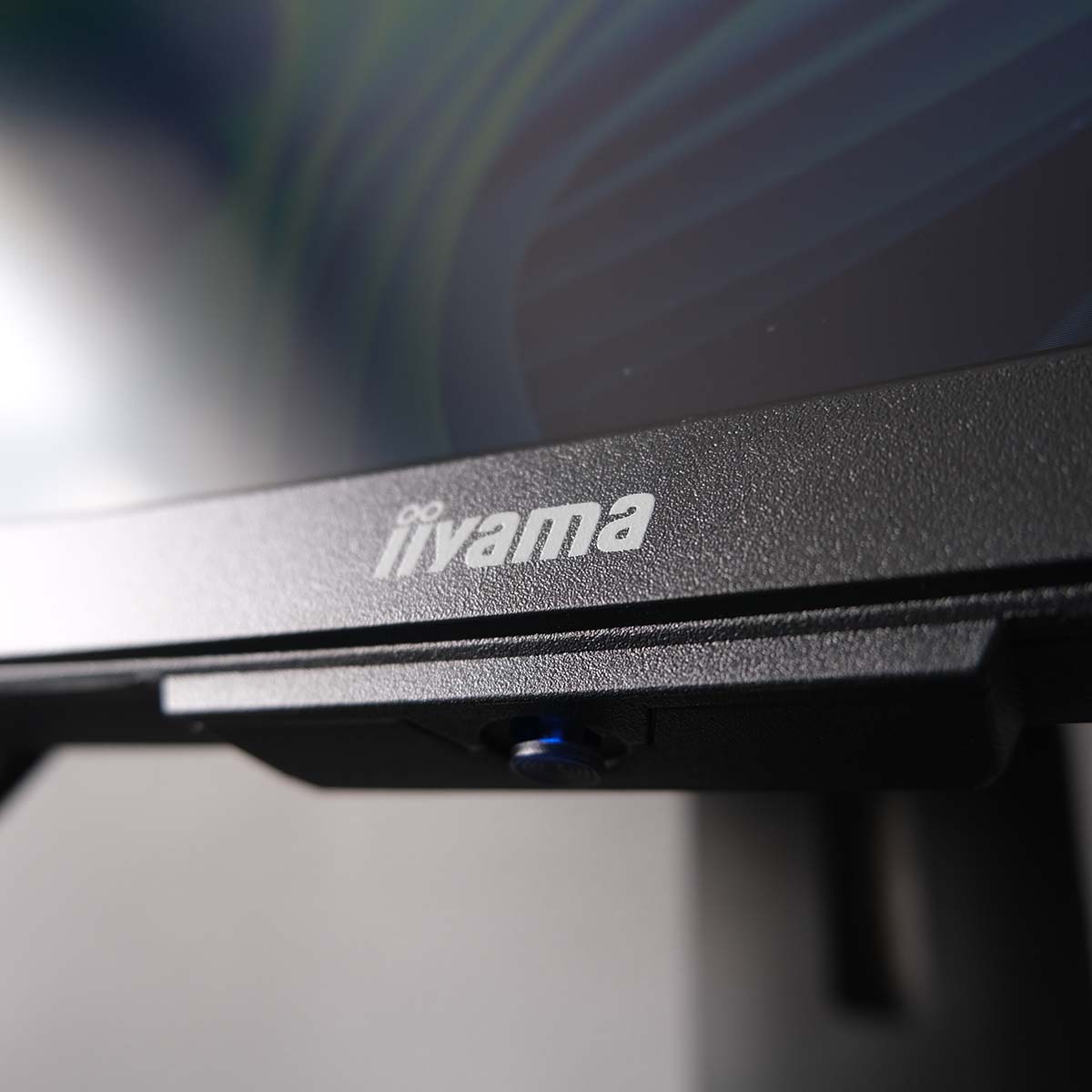 A close up of iiyama ProLite XCB3497WQSNPH-B1's chin, the monitor's joystick illuminated by a small blue LED.