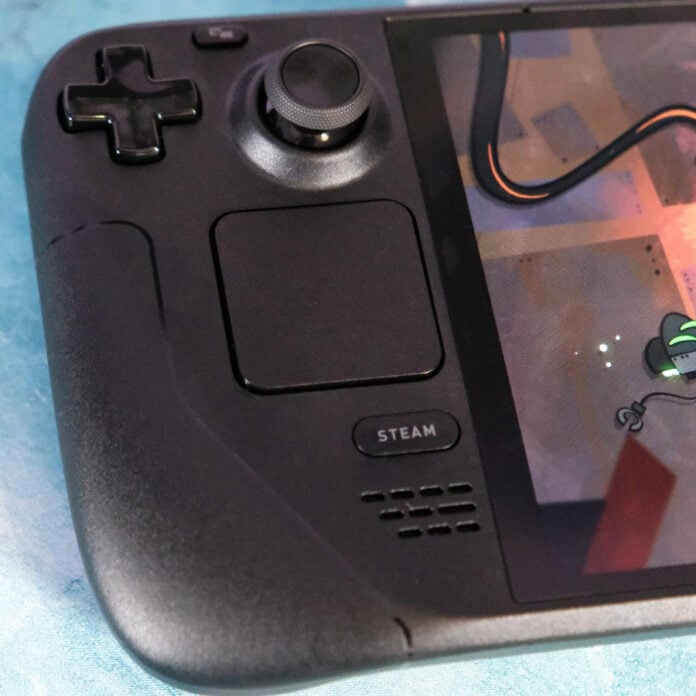 Close up of Steam Deck OLED, focussing on its track pad and 'Steam' button.