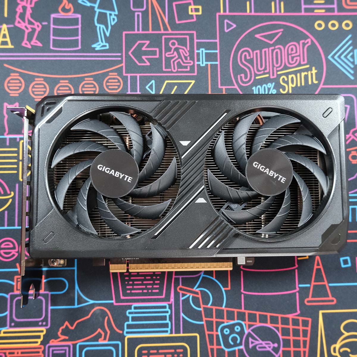 Gigabyte GeForce RTX 5050 Windforce OC graphics card lies flat, at a topdown angle, its frontplate facing the camera.