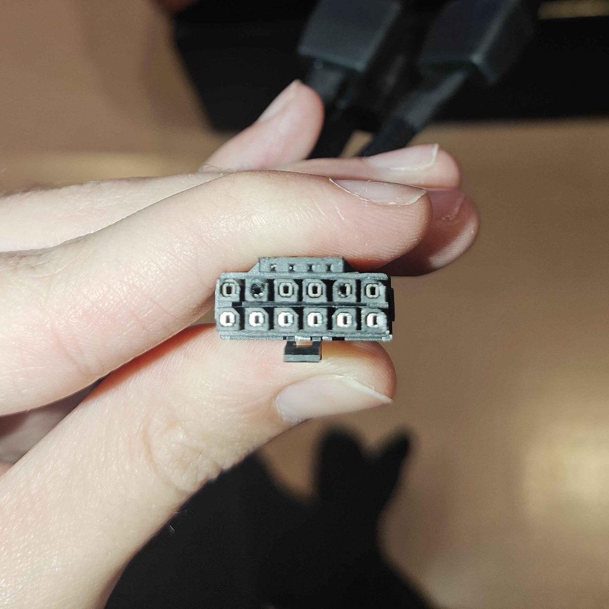 12V-2x6 power connector, illuminated by flashlight, featuring discolouration on several pins.