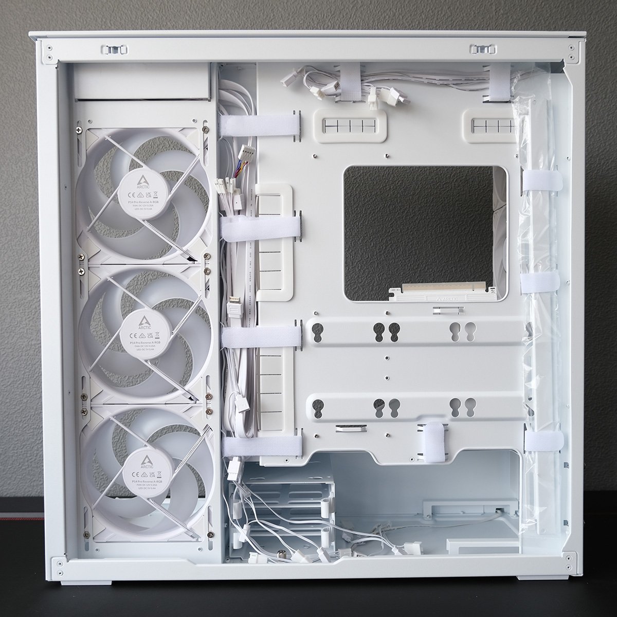 A side-on view of Arctic Xtender VG, focussing on the case's side panel, revealing pre-installed cable gromets and Velcro straps.