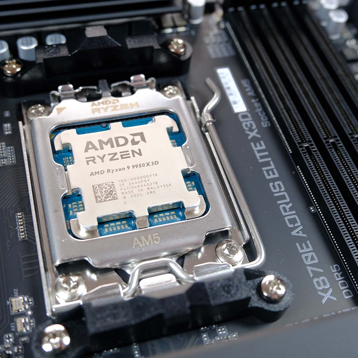An AMD Ryzen 9 9950X3D processor placed inside the AM5 CPU socket on Gigabyte X870E Aorus Elite X3D.