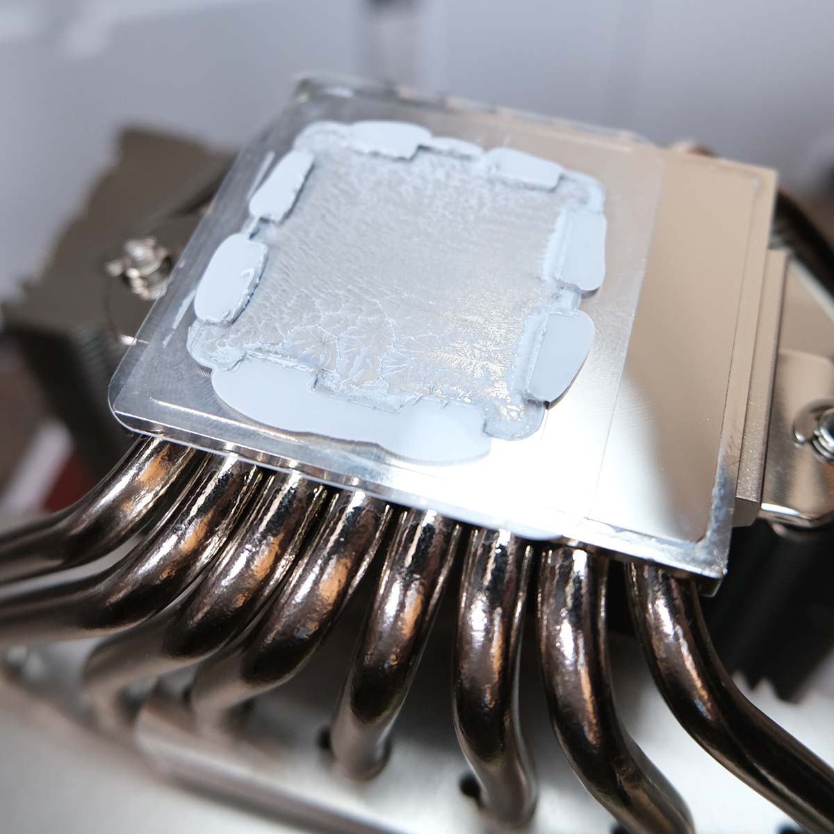 Close up of 'NA-TPG1' covered in thermal paste, following its removal from the processor.