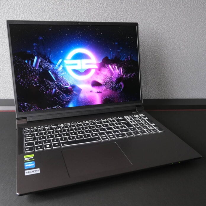 A wide shot of PCSpecialist Defiant 16, the laptop displaying a neon-rainbow PCSpecialist logo.