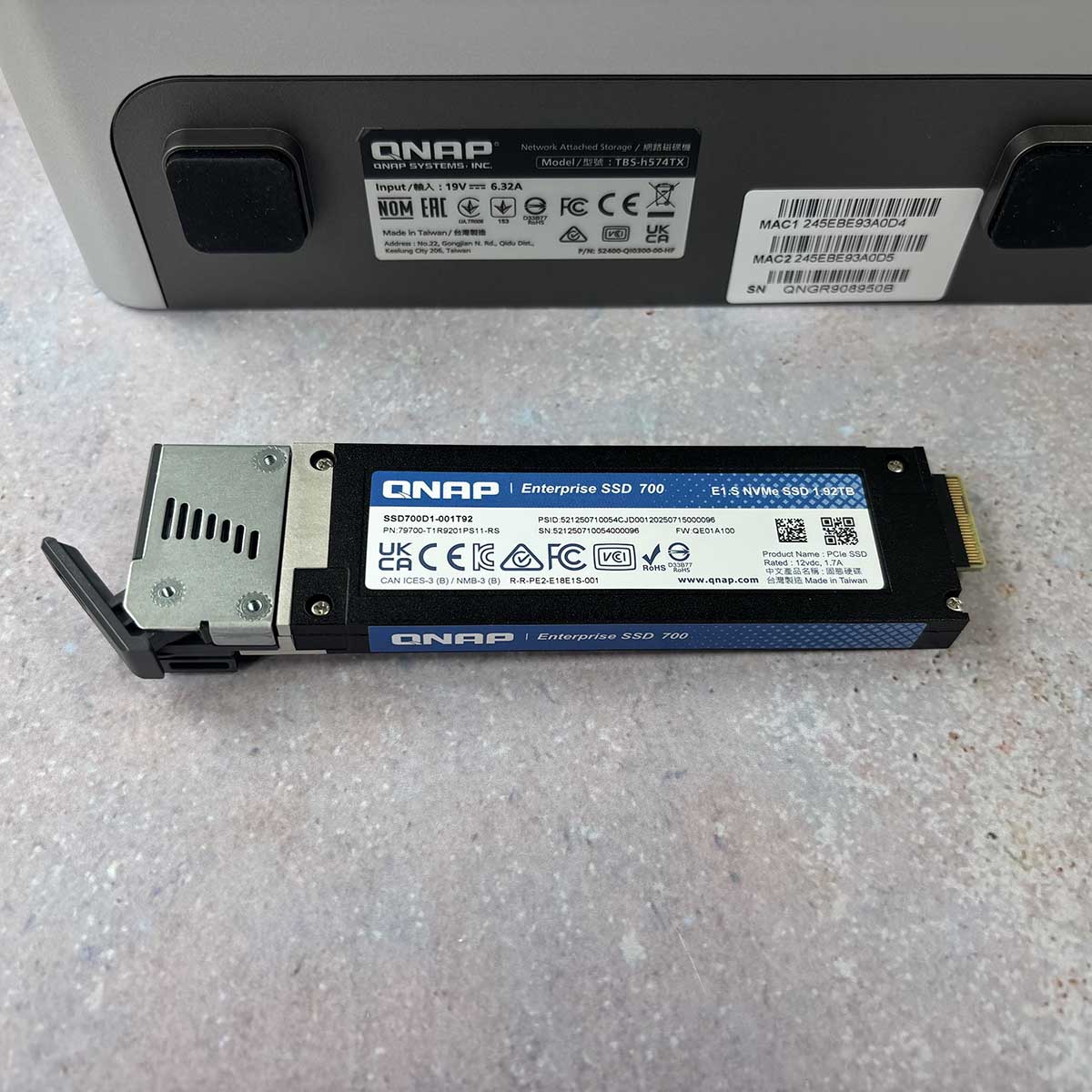 A picture of the QNAP E1.S SSD unit with the drive out in the open.