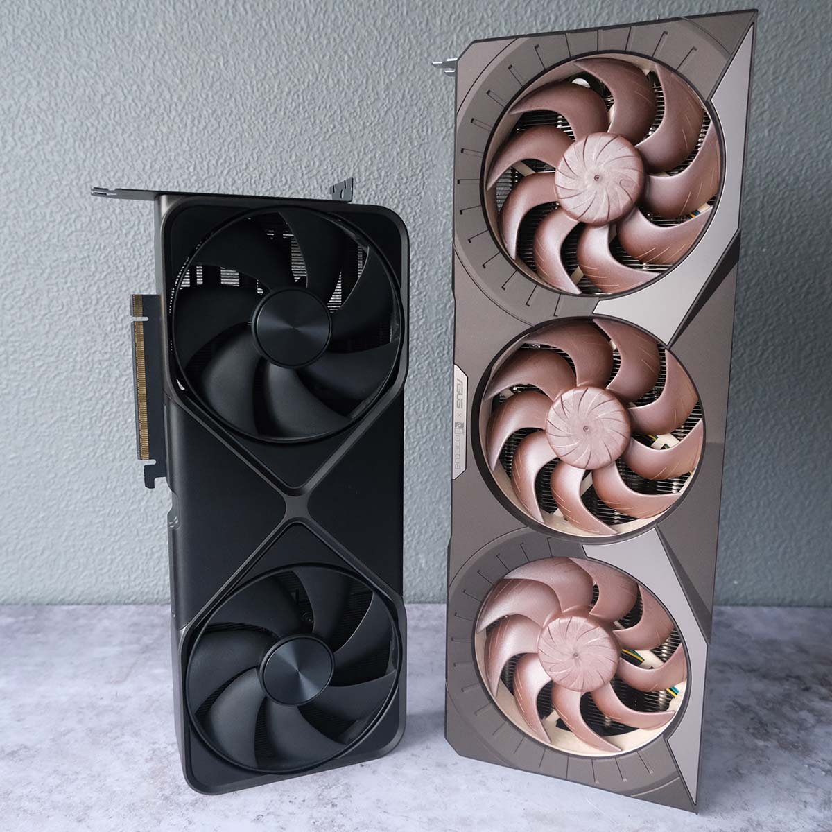 Nvidia GeForce RTX 5090 Founder Edition (left) and Asus GeForce RTX 5080 Noctua OC Edition (right) standing vertically next to one another.