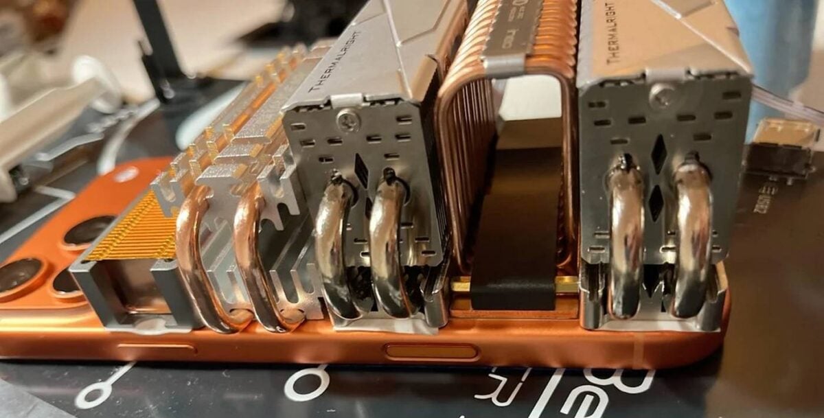 frankenstein iPhone 17 Pro Max with M.2 SSD coolers side.