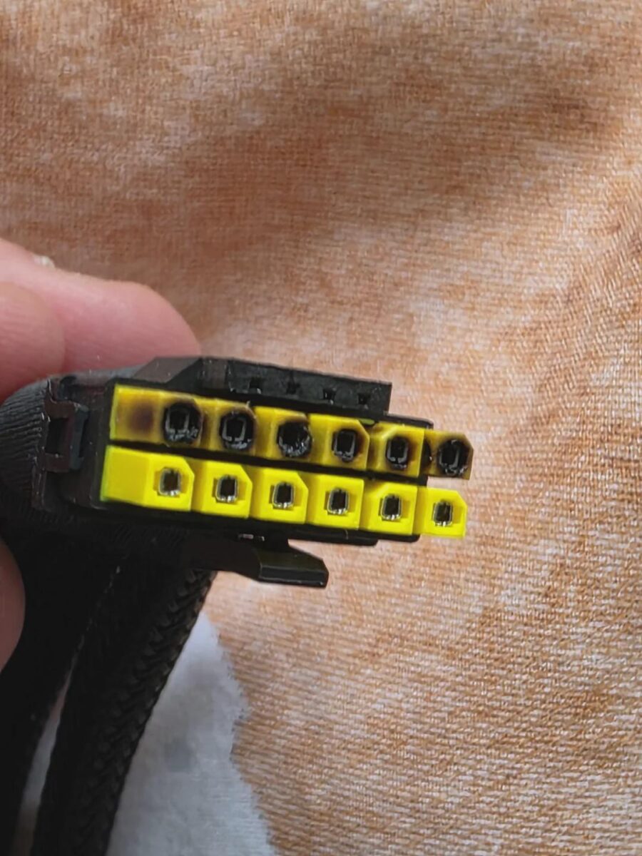 A scorched and partially melted RTX 5090 power connector with yellow MSI tops