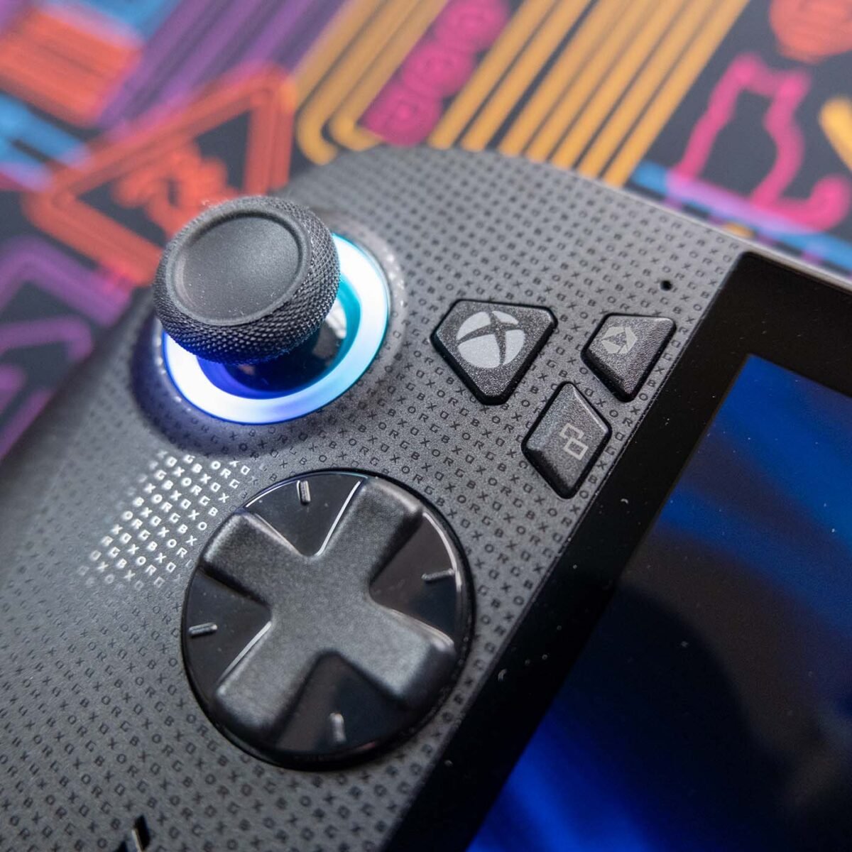 Close-up of left side buttons on ROG Xbox Ally X against a neon-style backdrop.