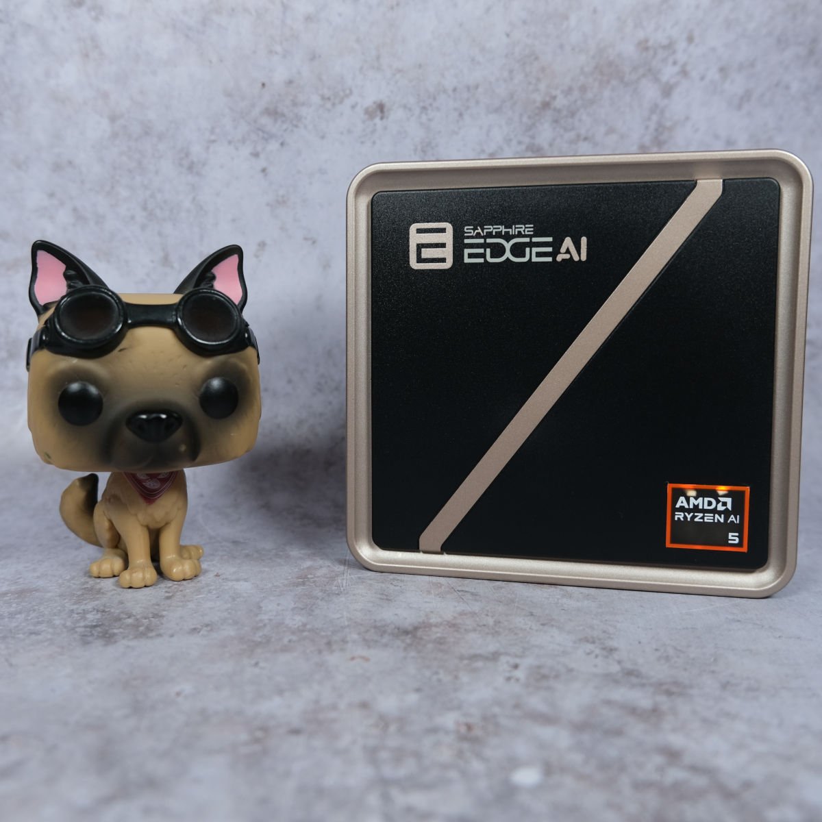 Sapphire Edge AI 340 (right) stood upright next to a Dogmeat Pop! Vinyl figurine (left).