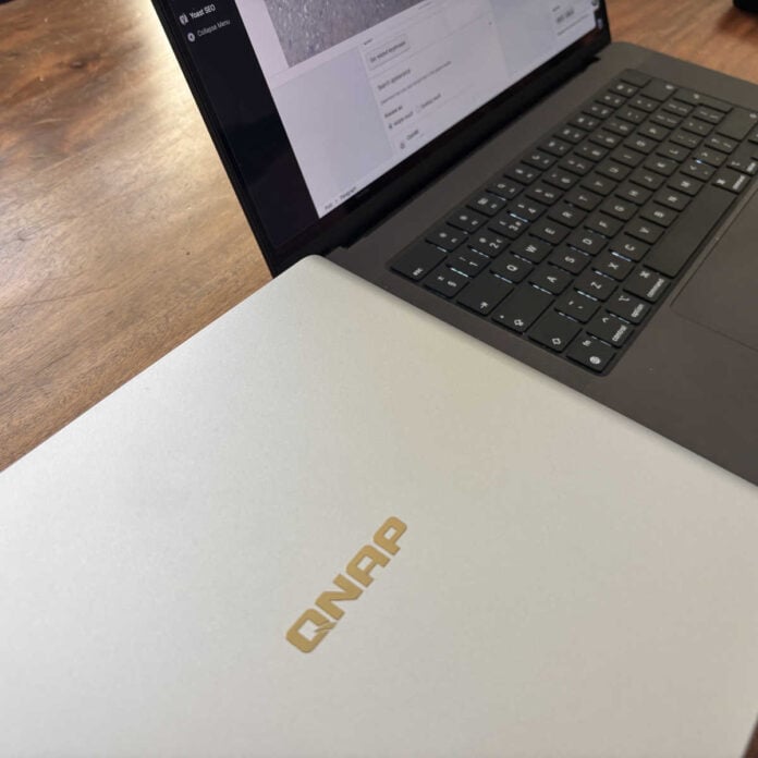 A picture of the QNAP all-flash NAS next to a MacBook.