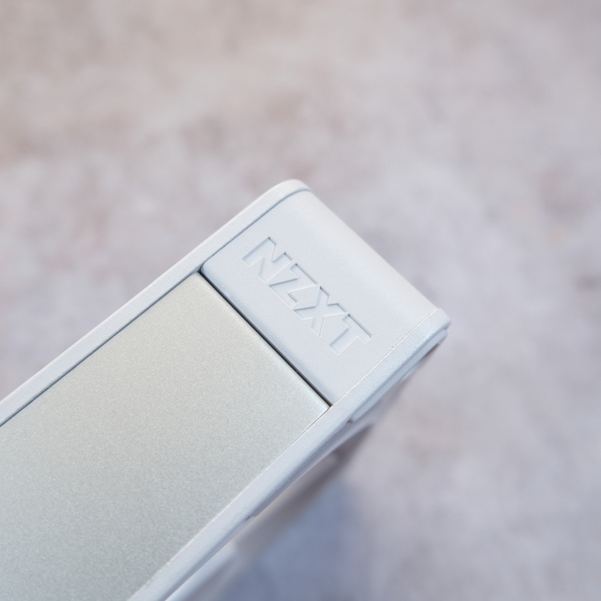 A close-up of the NZXT logo on the side of a white F360X.