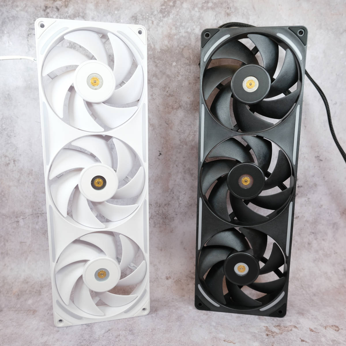 An NZXT F360X White (left) and Black (right) standing upright against a porcelain backdrop.